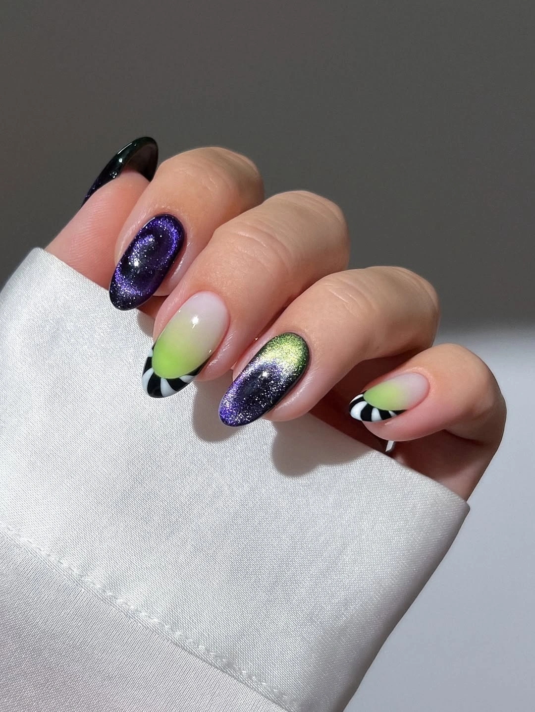 Short oval nails with black glitter and pink drip accents