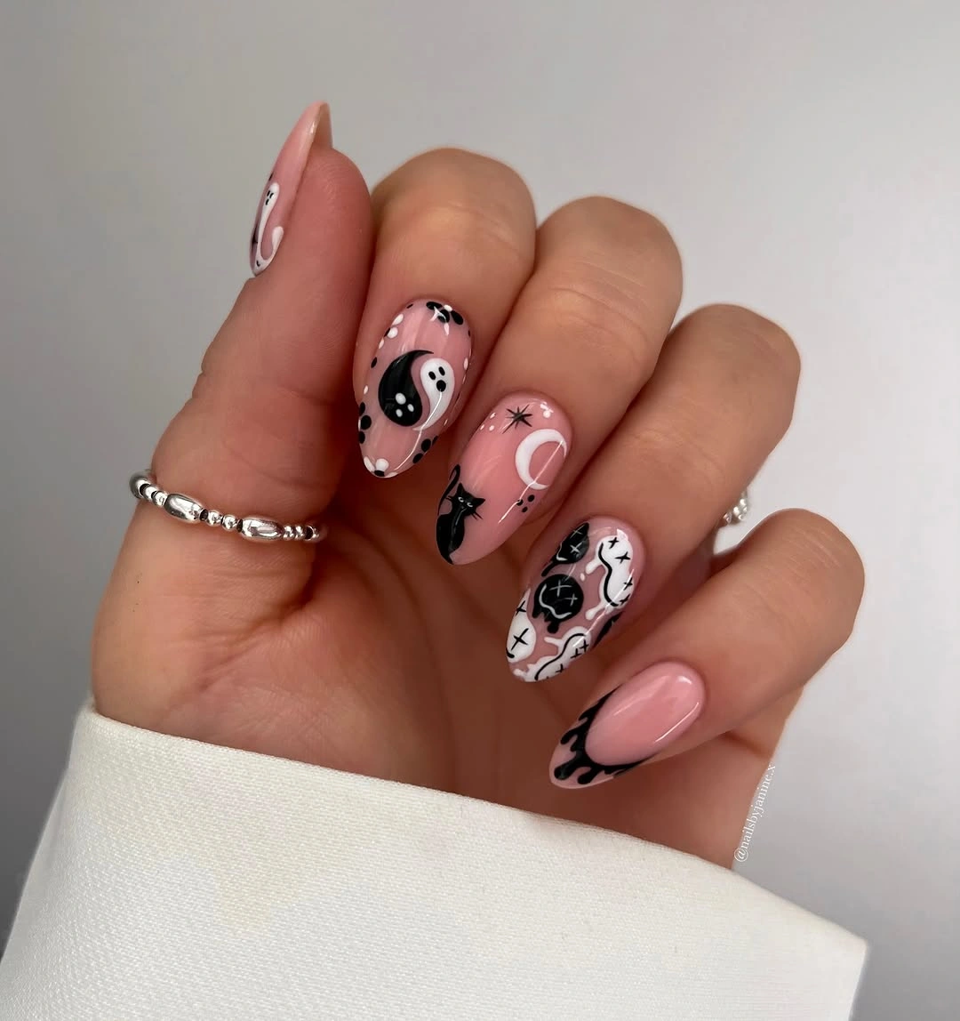 Blush almond nails with moon, yin-yang, and monochrome symbols