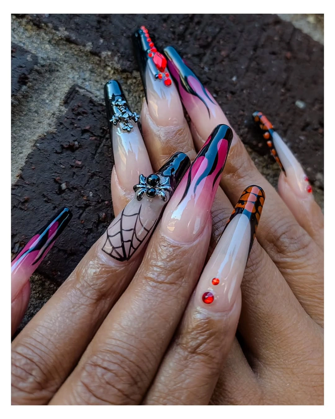 Extreme stiletto nails with colorful swirls, webs, and crystals