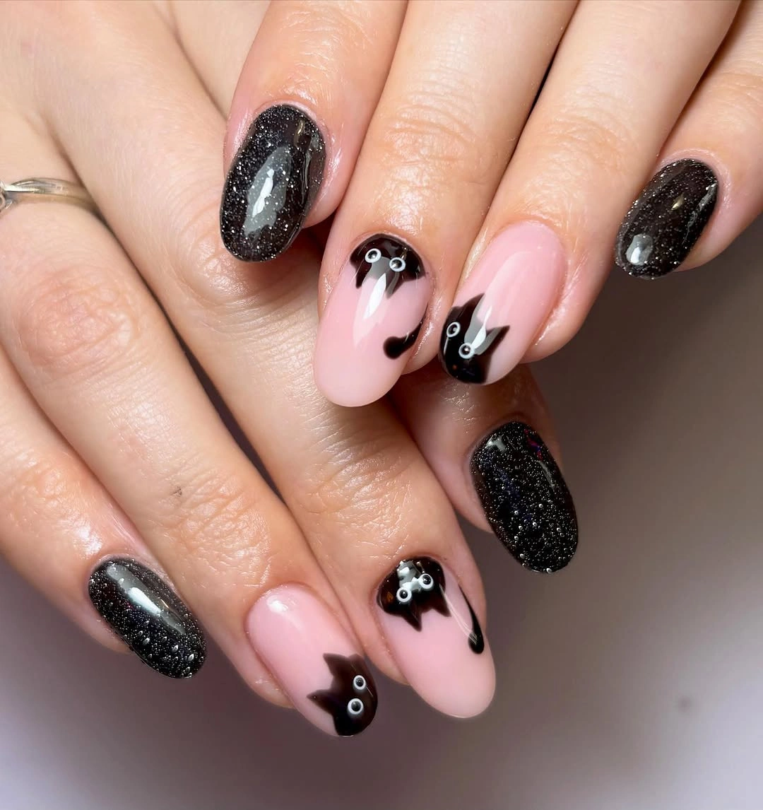 Short glitter nails with pink bases and black dripping tips