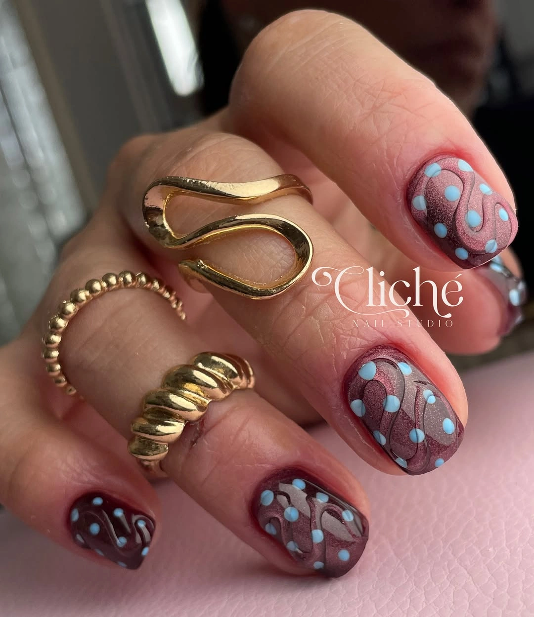 short dusty mauve oval nails with scattered tiny pale blue dots