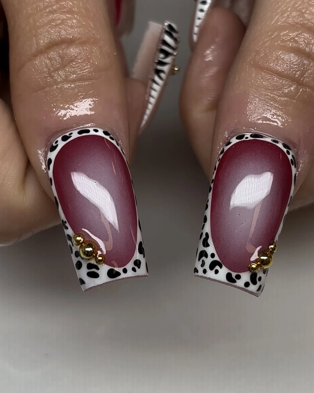 medium square mauve nails with burgundy panels dotted borders and small gold details