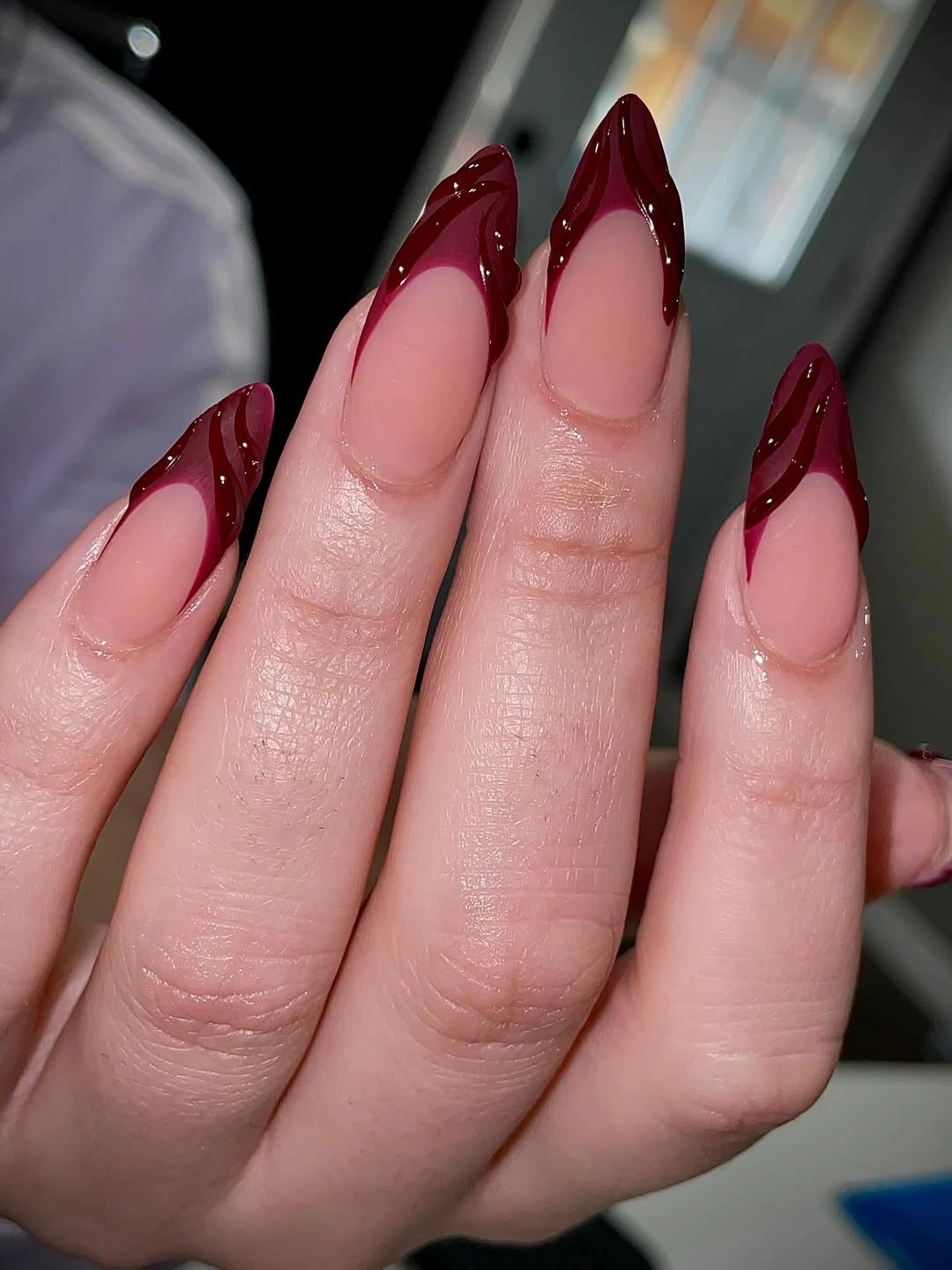 long pale pink almond nails with pointed burgundy French tips and tiny light dots