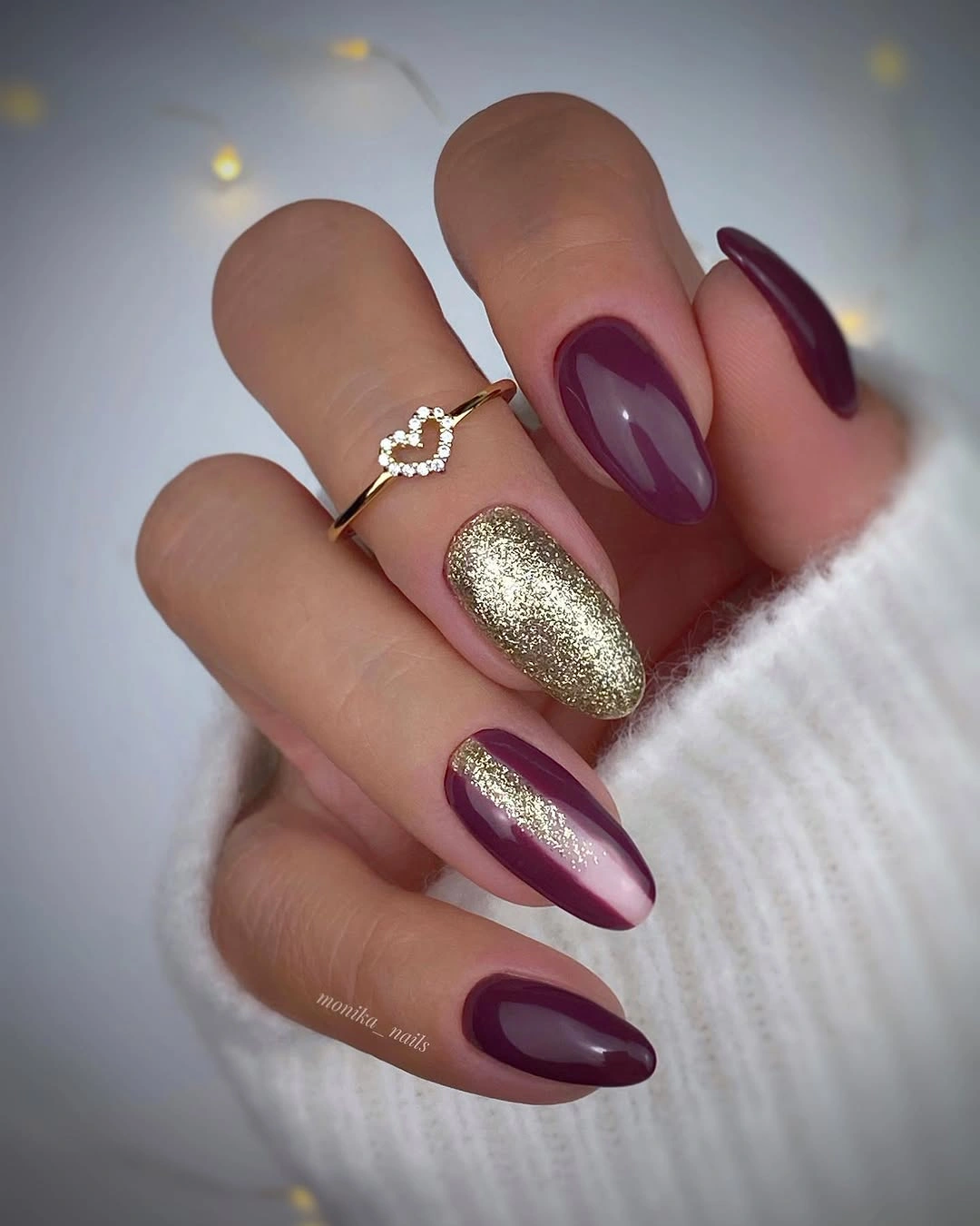 long plum burgundy almond nails with one sparkling gold accent nail
