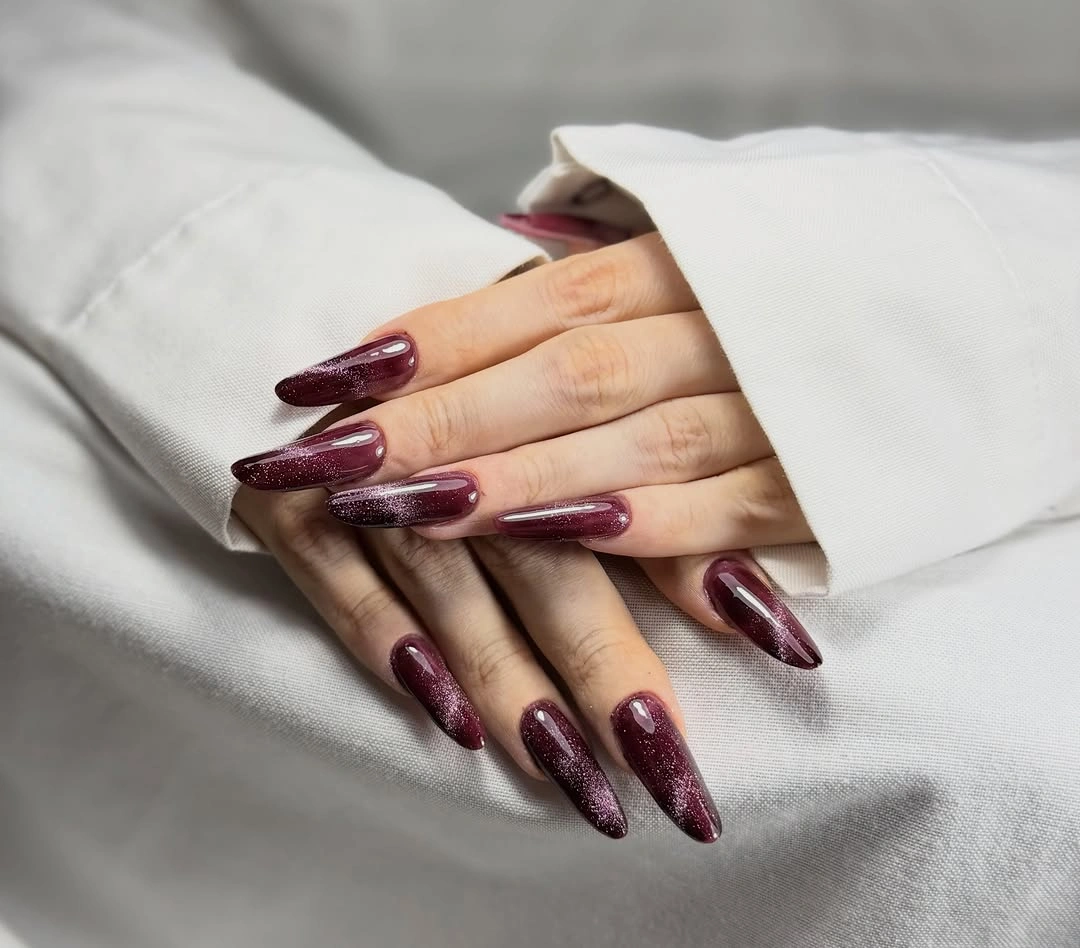 long pointed almond nails in a reflective dark wine burgundy shade