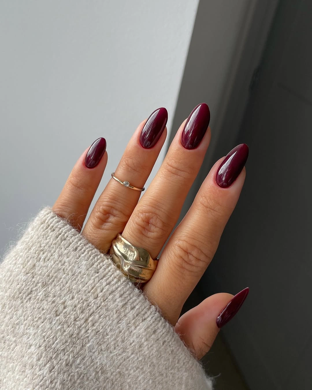 medium almond nails in a uniform glossy dark maroon color