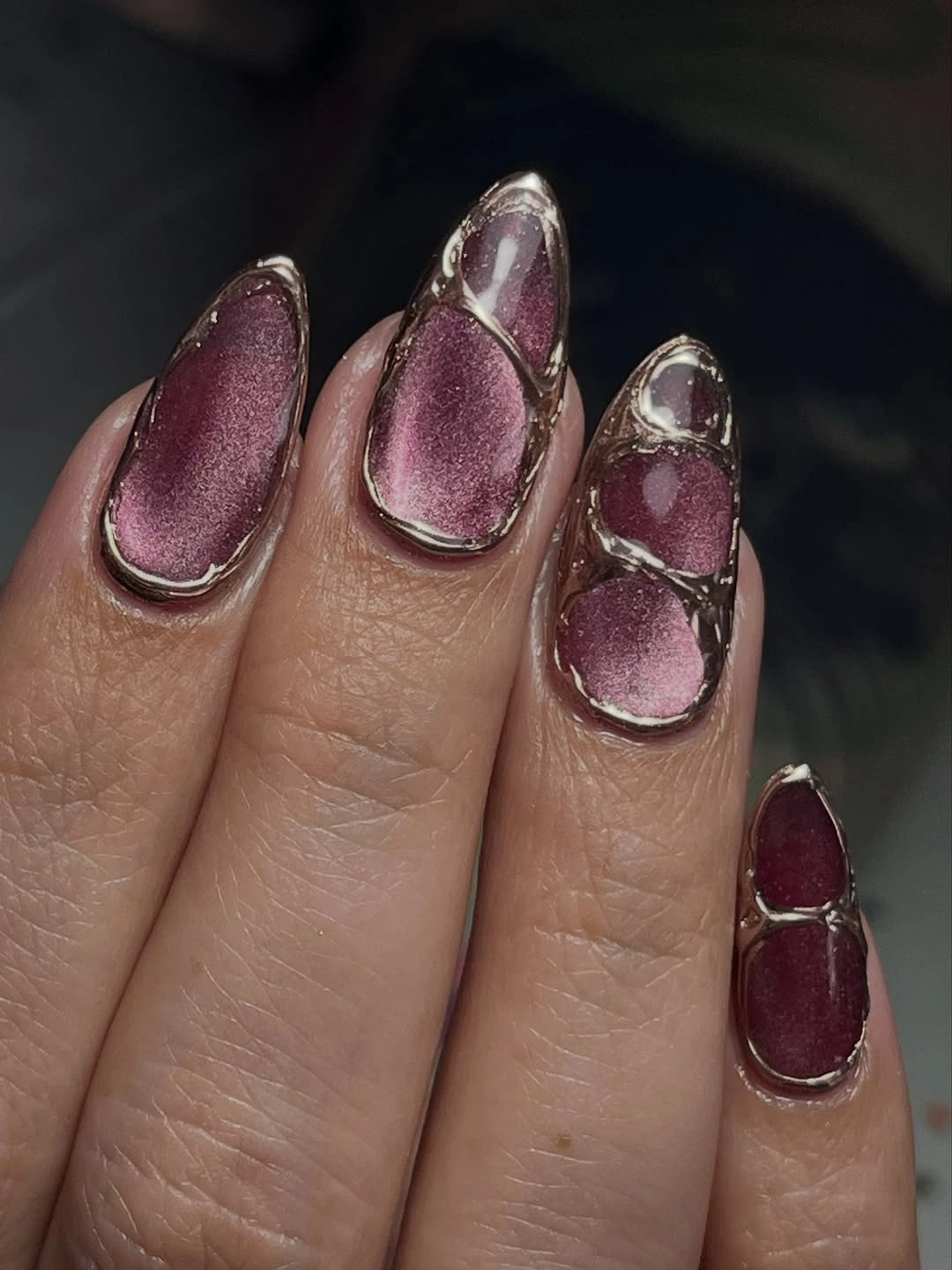 mauve plum almond nails with dark metallic outlines and pale linear accents
