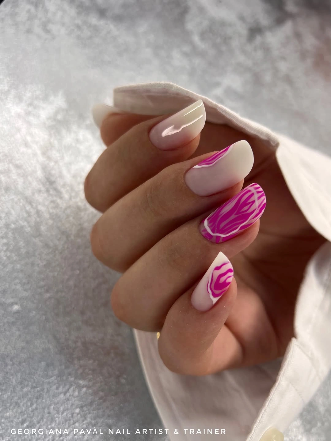 soft nude almond nails with bright fuchsia abstract swirl accents