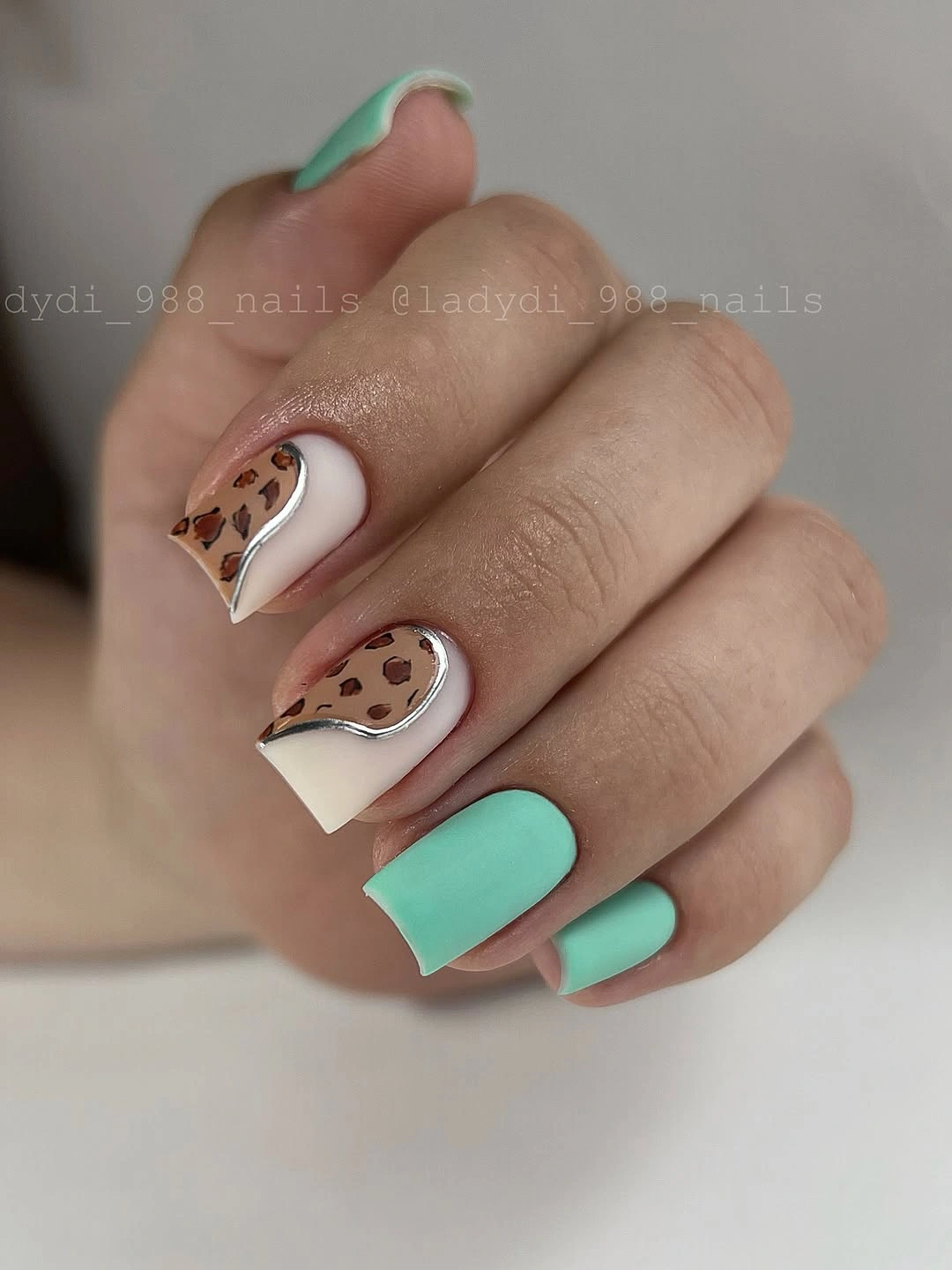 short mint and white square nails with brown spotted and small botanical accents
