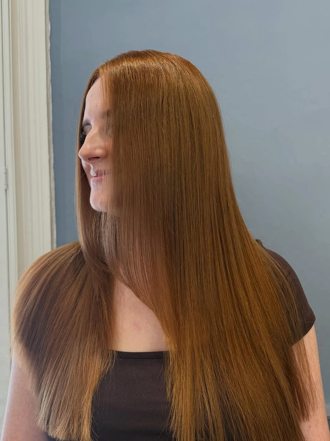 Long straight copper-brown hair with a centered part and clean ends