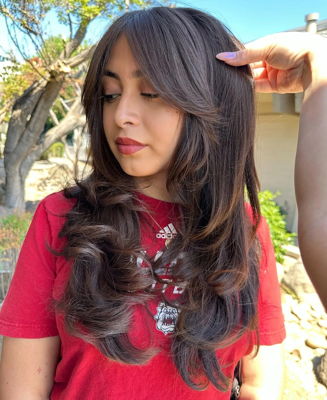 Long dark hair with heavy curtain layers and soft curled ends