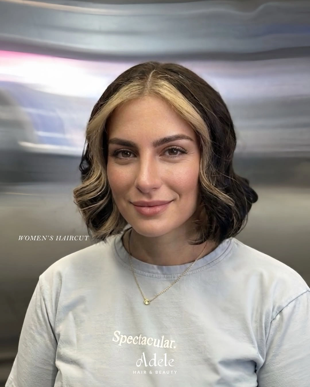 Short dark bob with a center part and pale blonde face-framing section