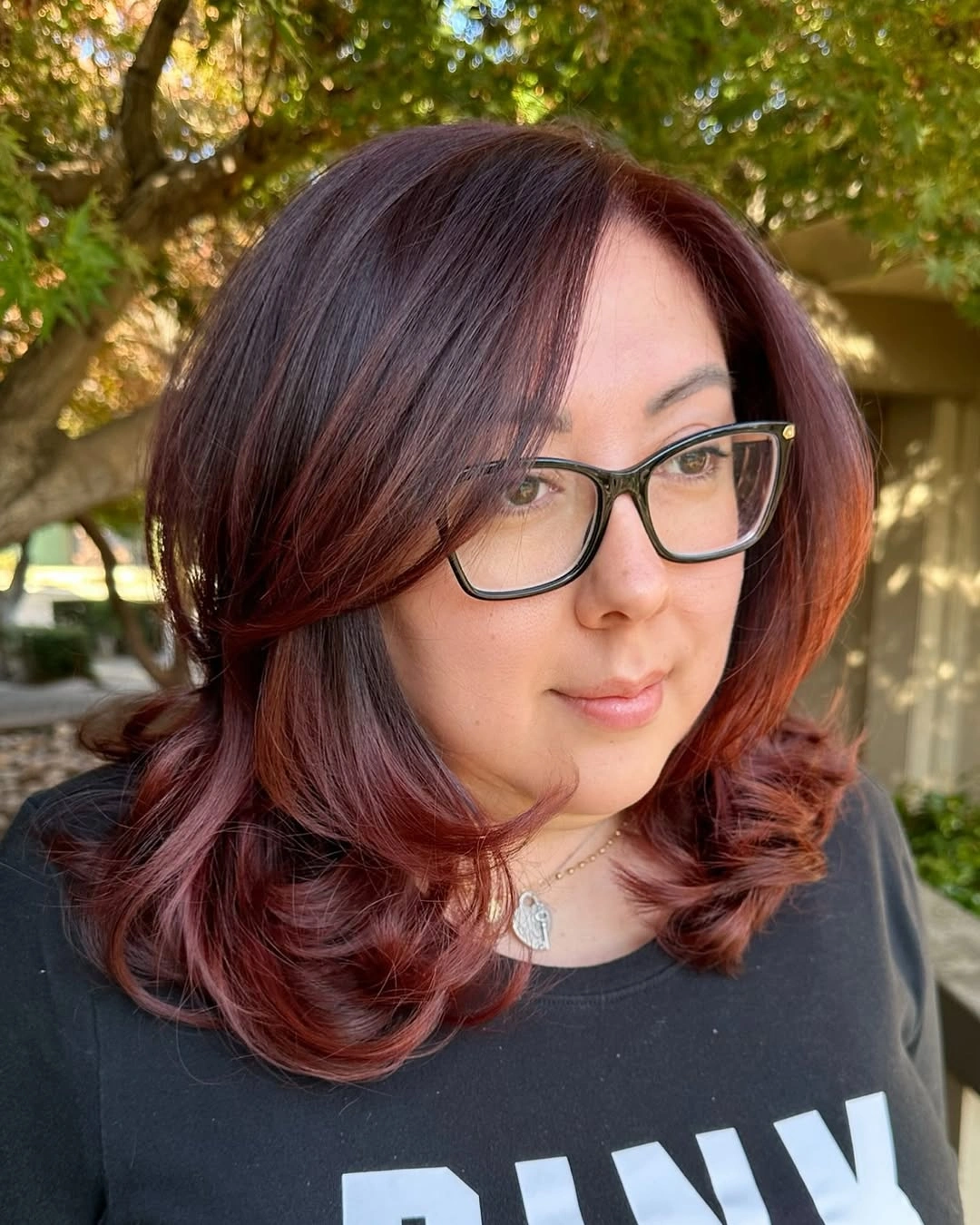 Shoulder-length auburn middle-parted hair with rounded layered waves