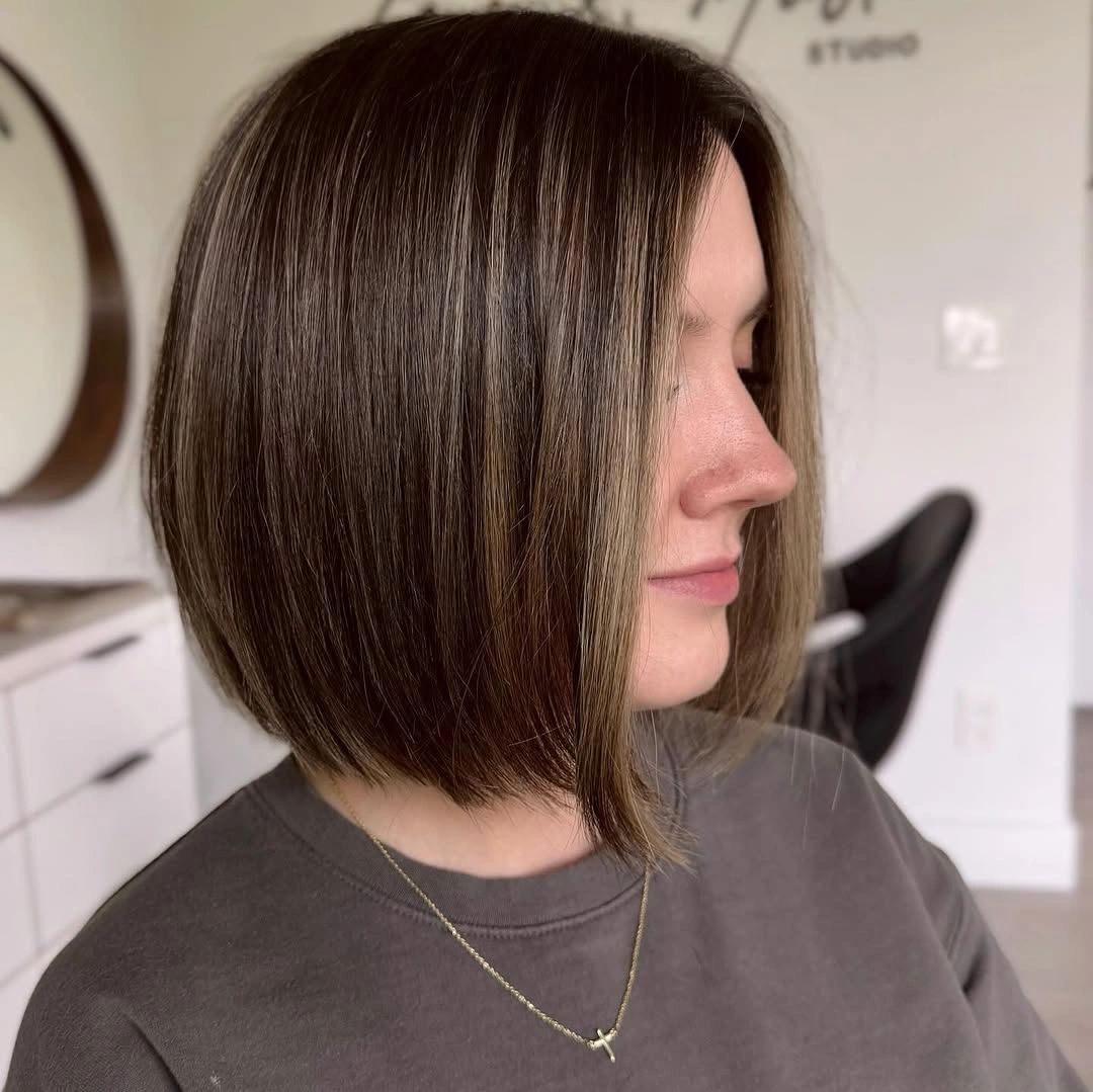 Short smooth dark bob with a centered part and tucked jaw-length ends