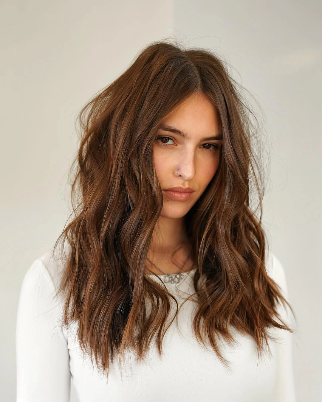 Long brown center-parted hair with broad waves and face-framing movement