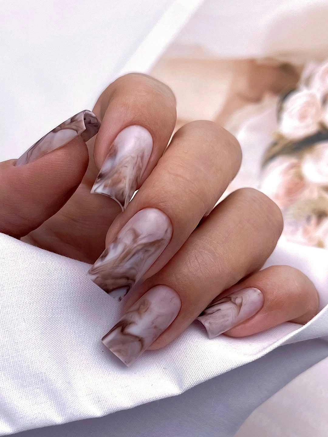 Long nude square nails with smoky brown and pale marbled-looking swirls