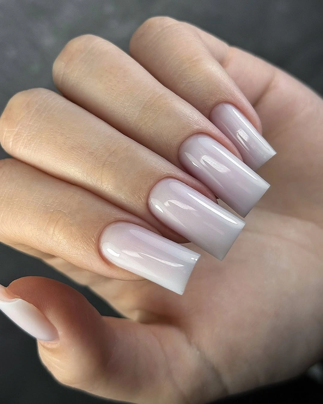 Long square nails in milky pearl-like white with soft translucent gloss