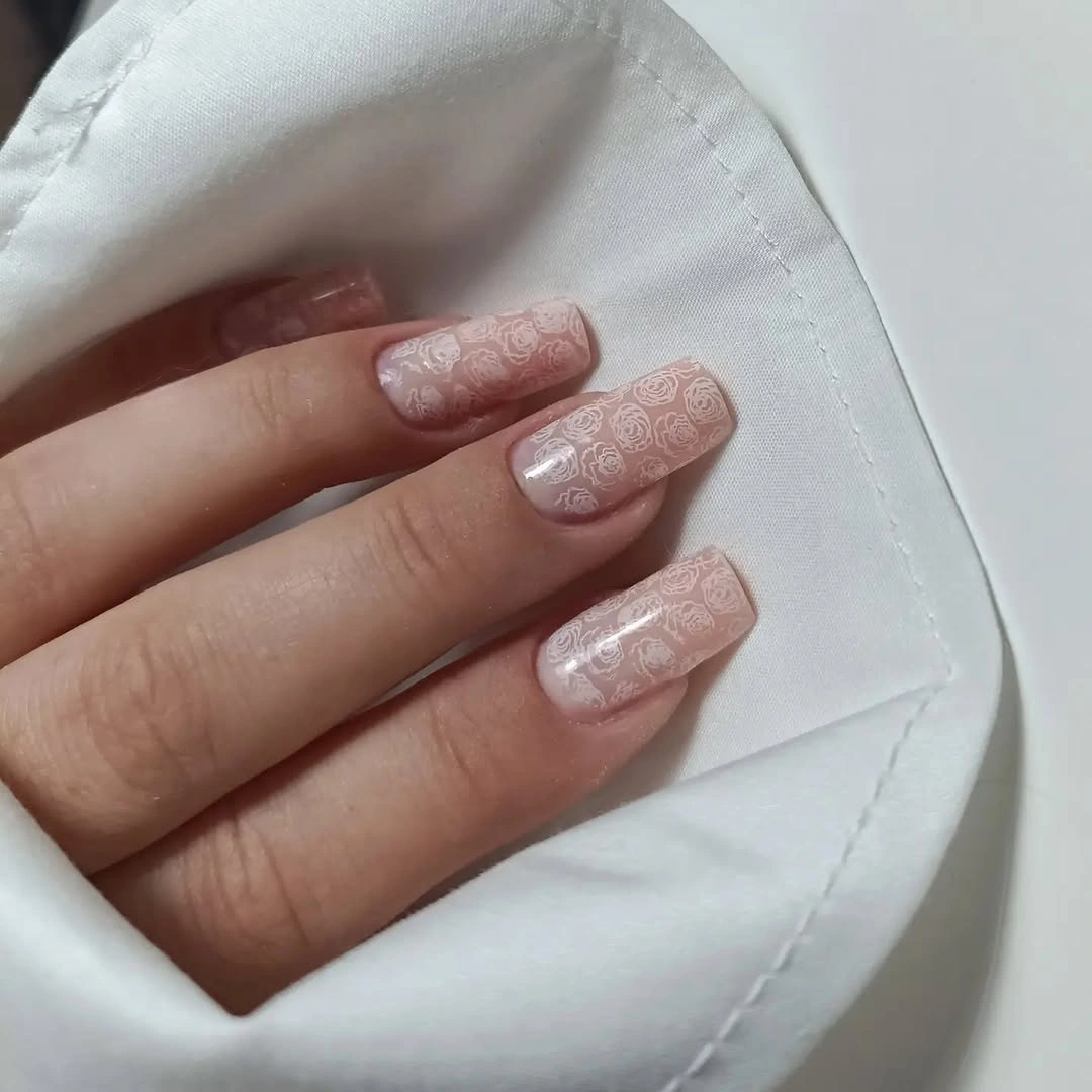 Soft beige nude nails with fine raised-looking floral lace-like texture
