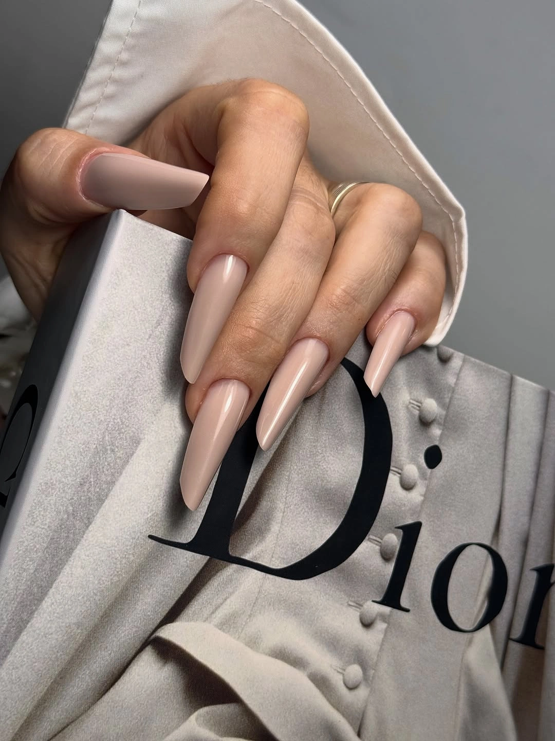 Long almond nails in an even glossy muted blush nude shade