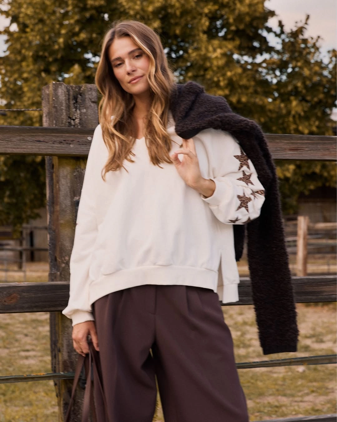 Cream layered top with dark brown trousers and textured scarf