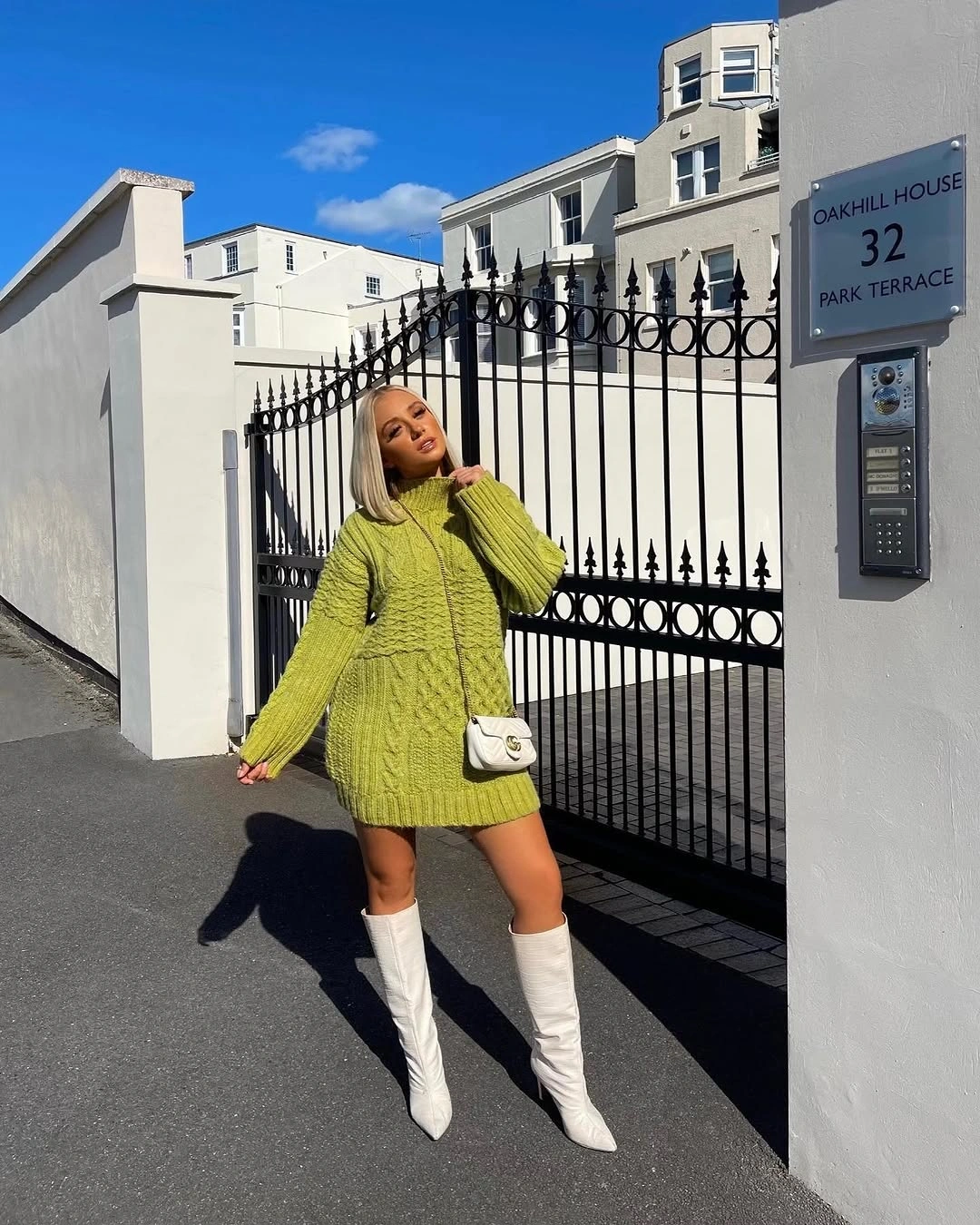 Lime green knit sweater dress with white knee boots and bag