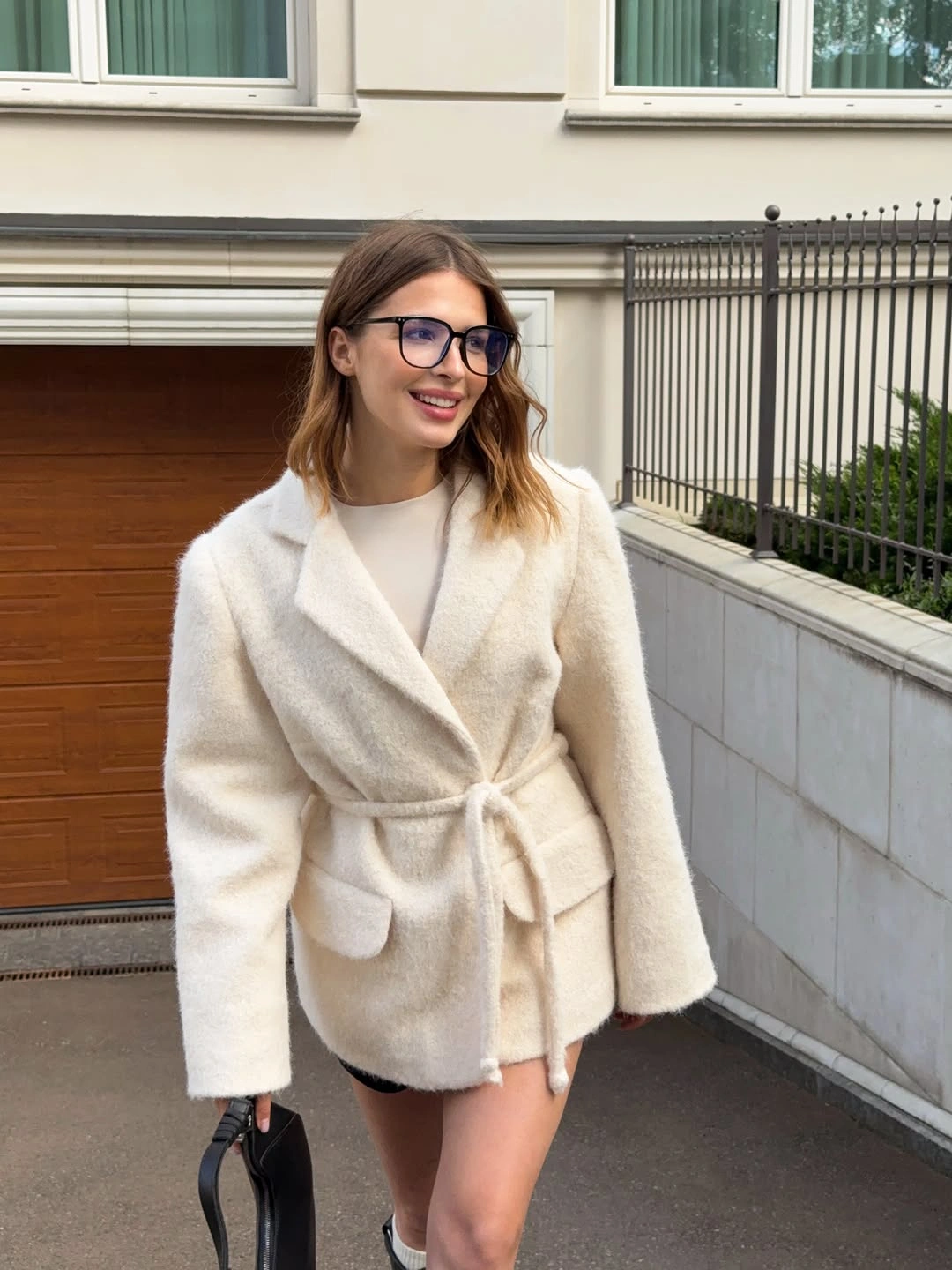 Cream belted wrap coat with black bag and boots