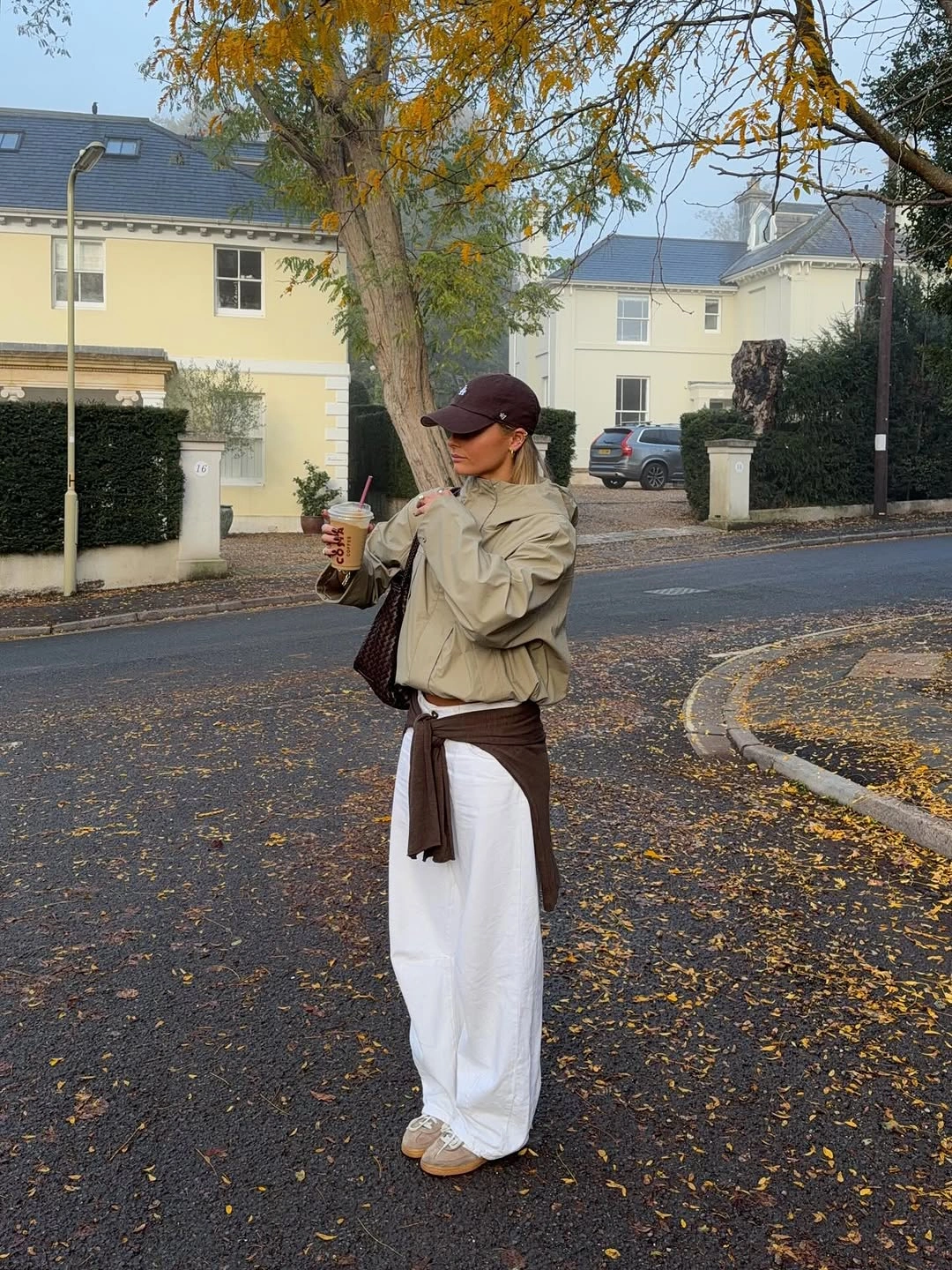 Cream puffer jacket with white trousers brown knit and cap