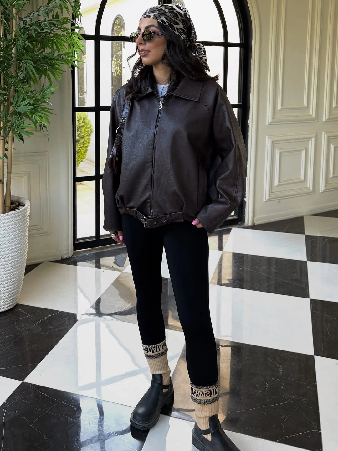 Dark leather-look bomber with black trousers leopard headscarf and boots