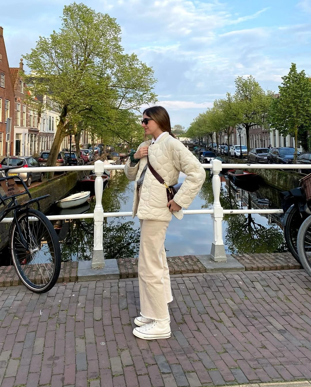 Ivory quilted jacket with cream trousers trainers and brown bag