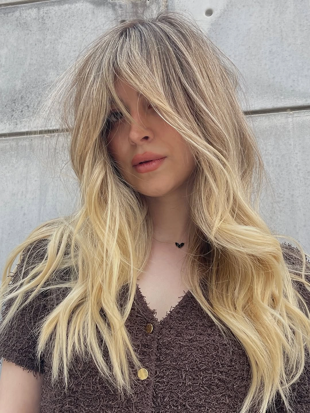 Long airy neutral blonde hair with darker root area