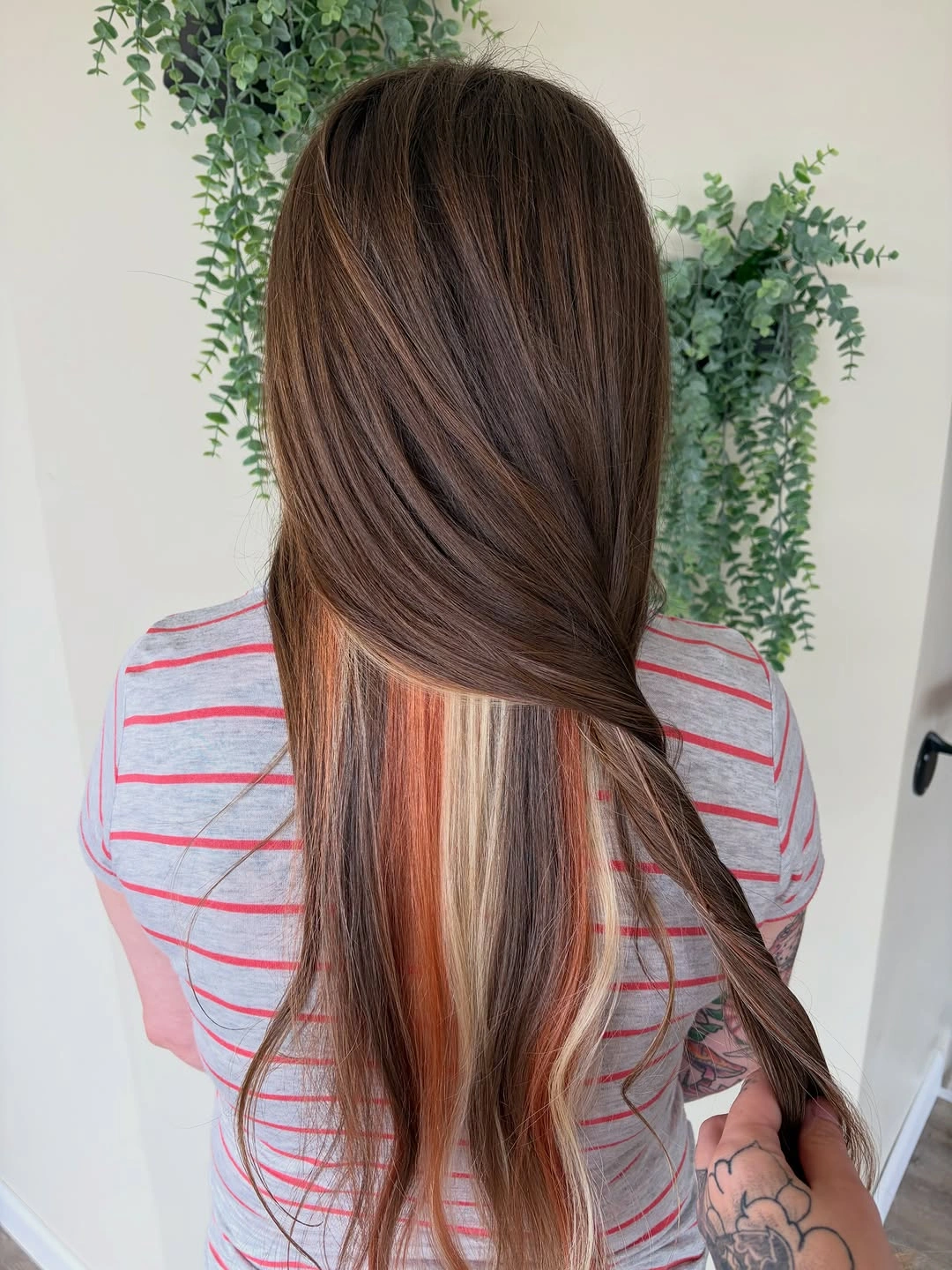 Long dark brown hair revealing copper and blonde underlayers