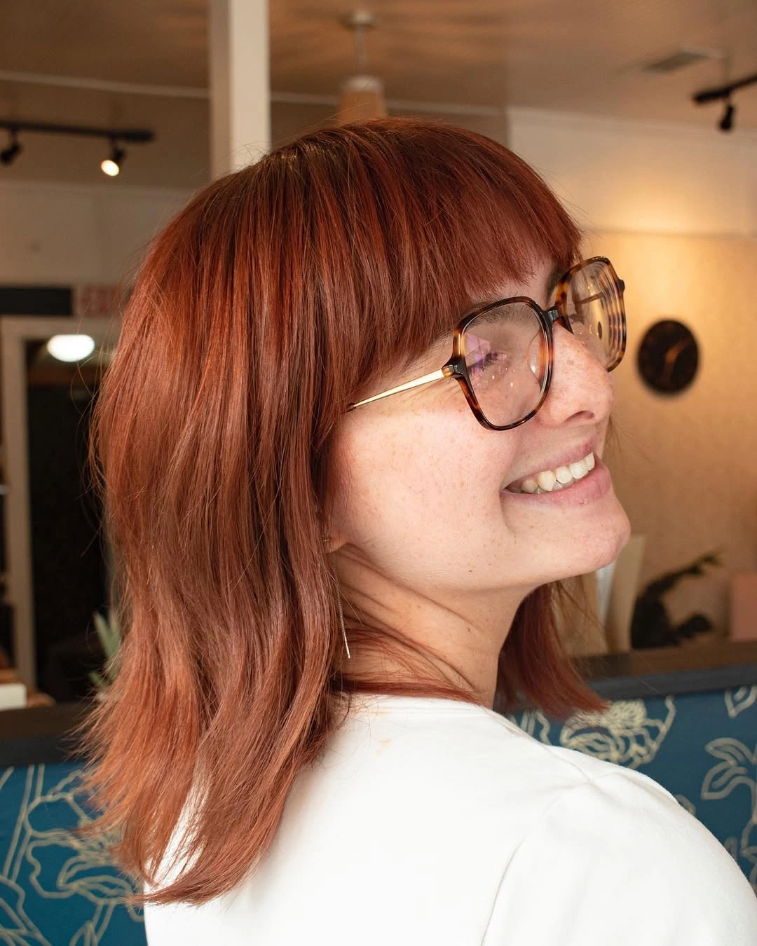 Soft auburn layered hair with full fringe and waves