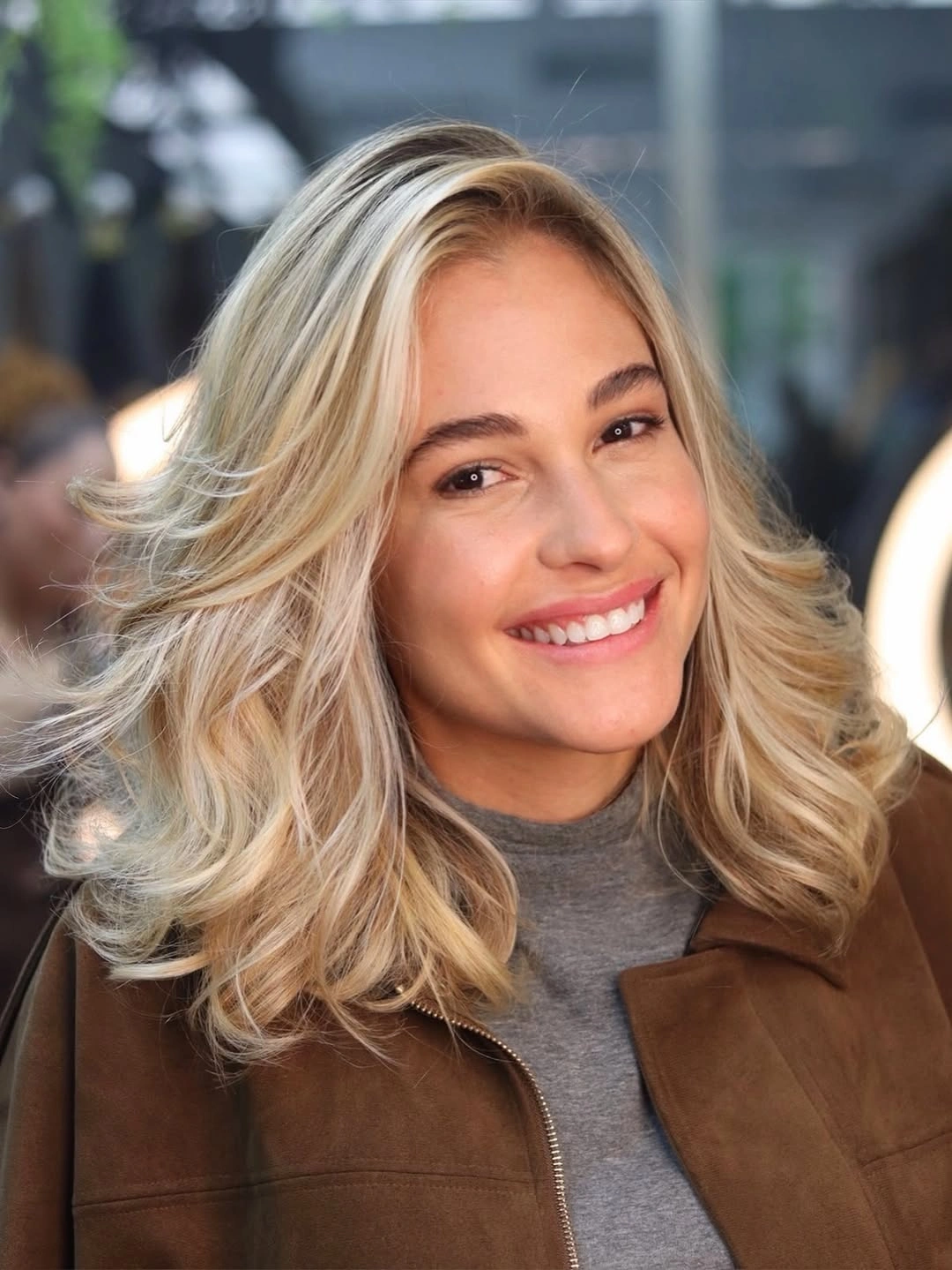 Medium blonde layers with deep side part and volume
