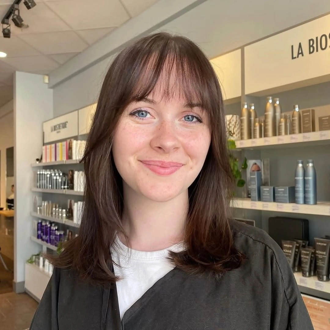 Shoulder length dark hair with wispy bangs and curved ends