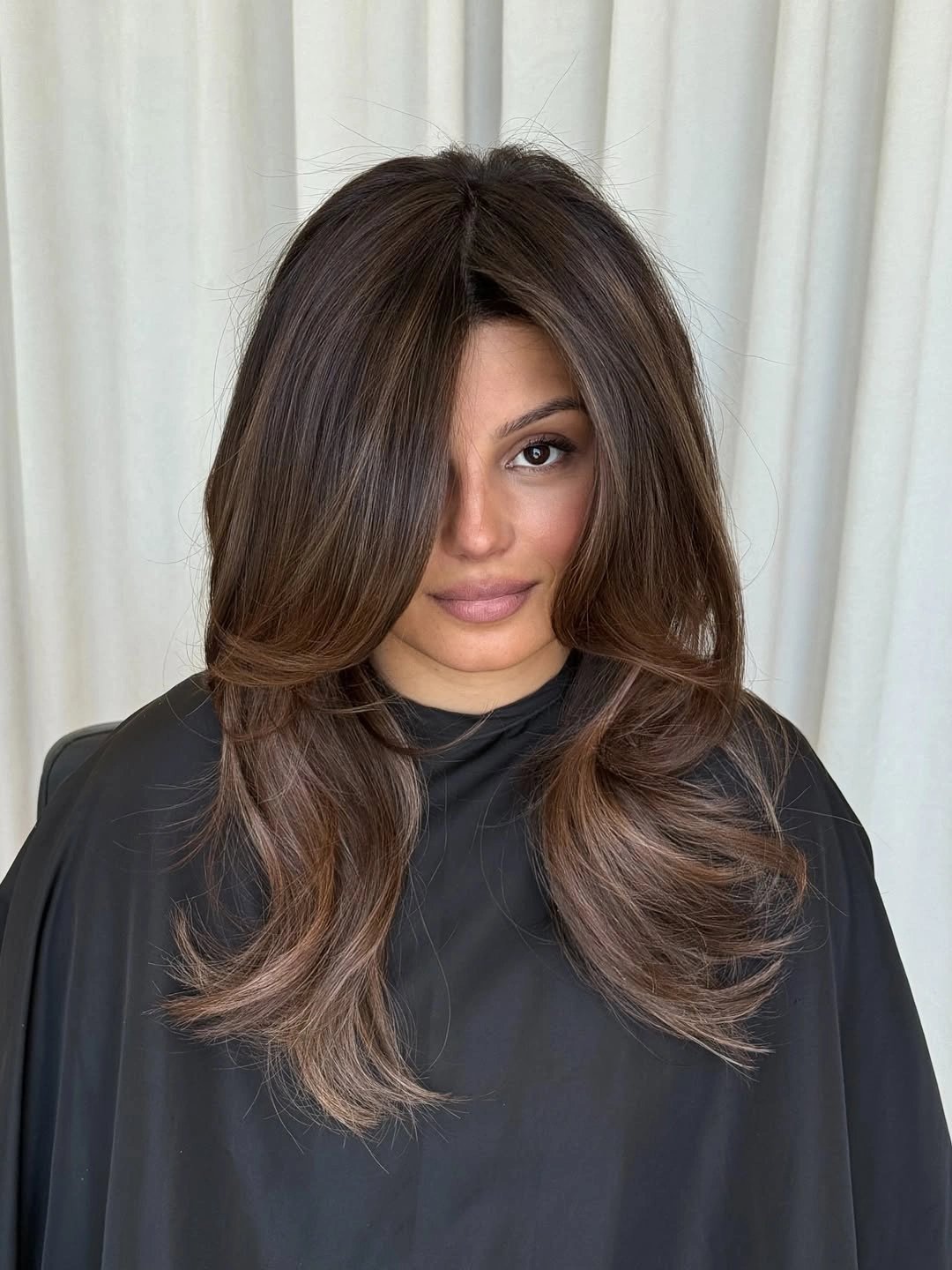 Long brunette hair with deep side sweep and cascading layers