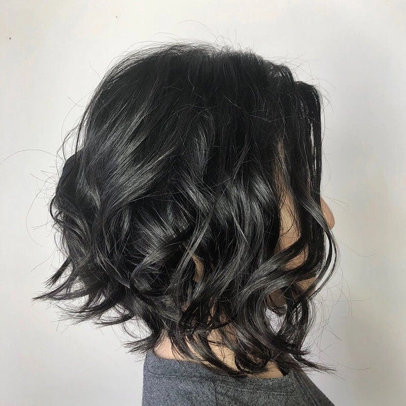 Short dark layered bob with loose waves and lifted back