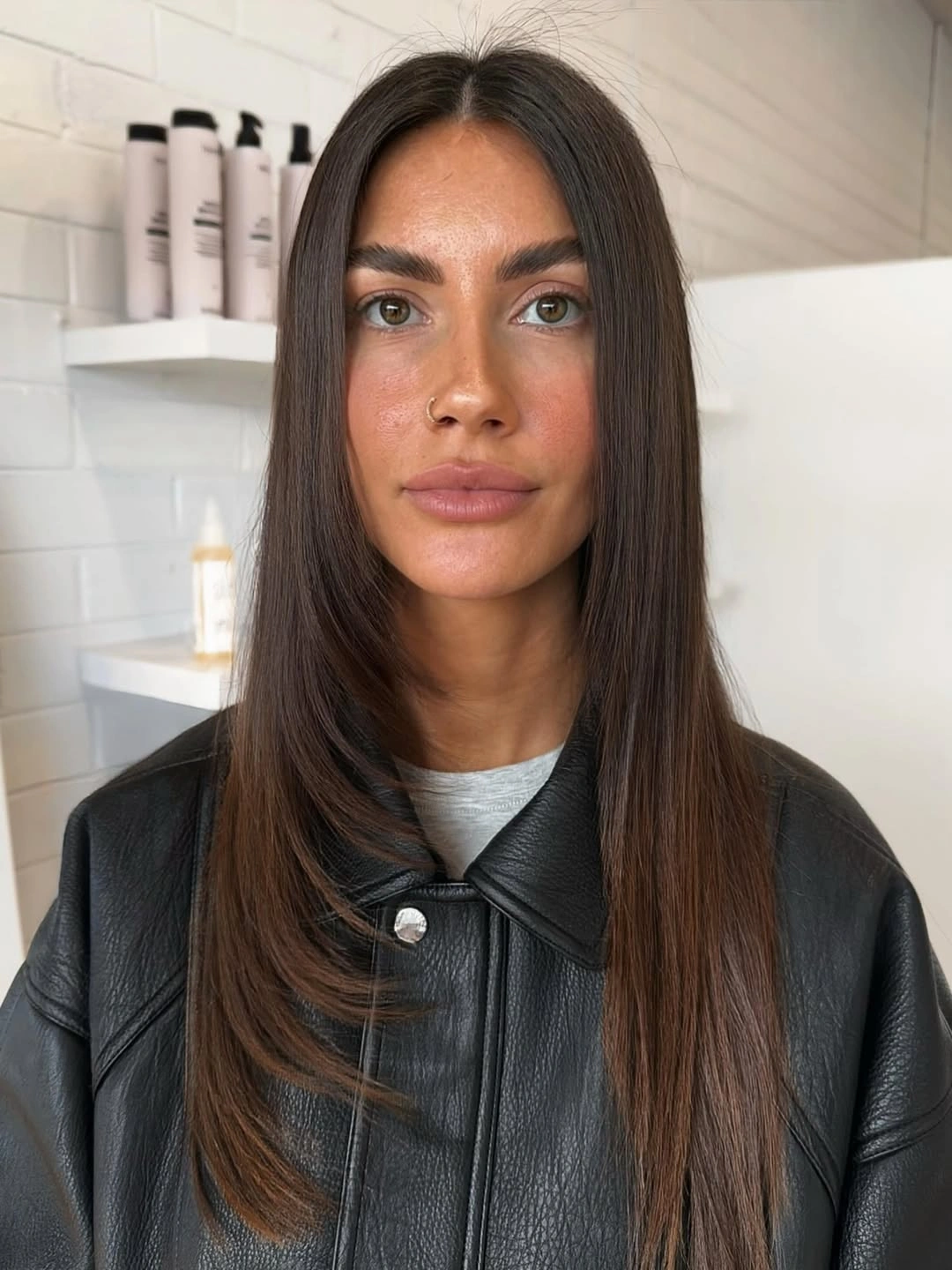 Sleek long brunette hair with center part and subtle face layers