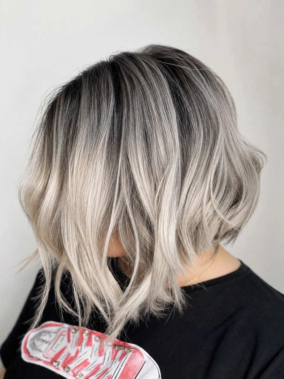 Textured silver bob with dark roots and broken waves