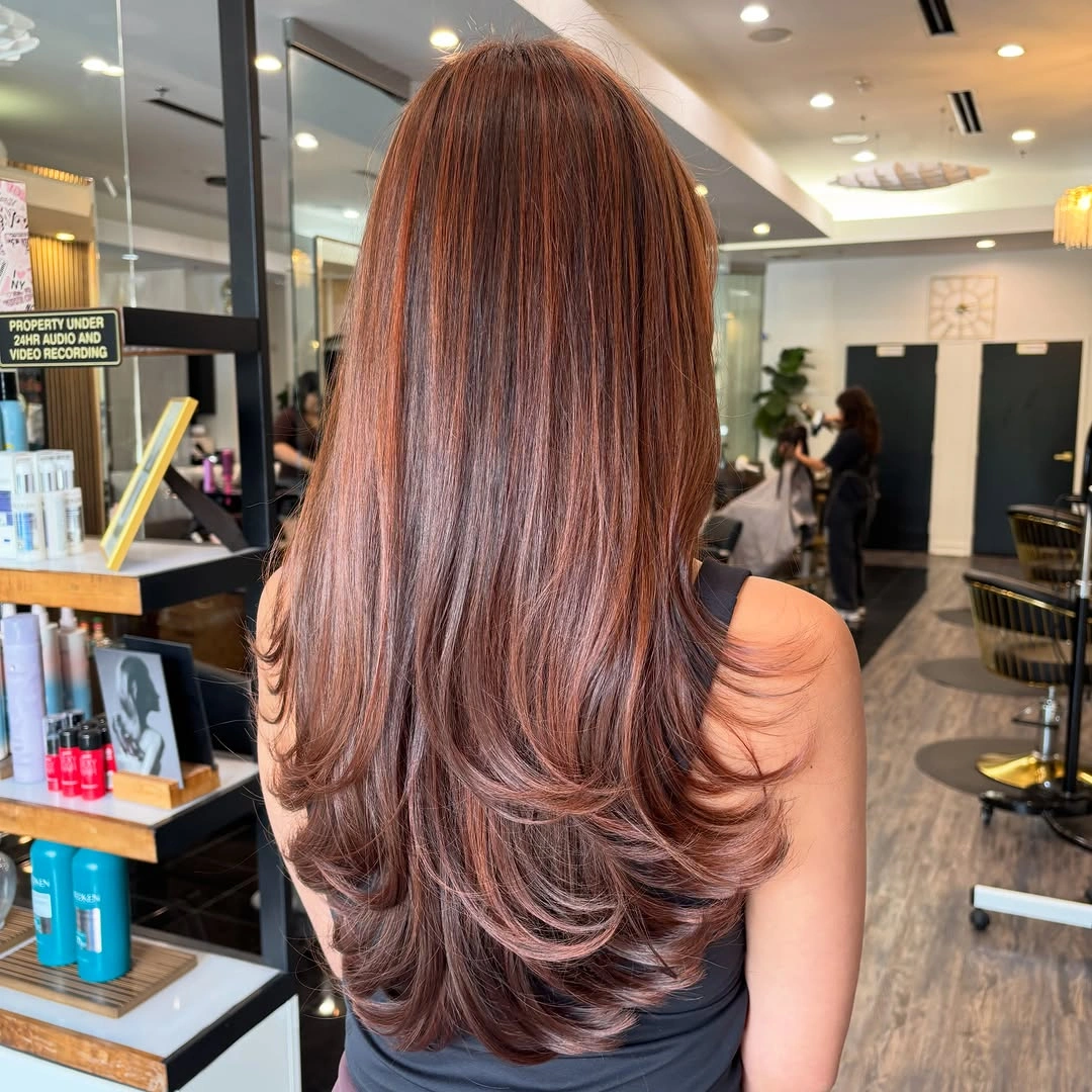 Long auburn hair with bouncy layers and rounded ends