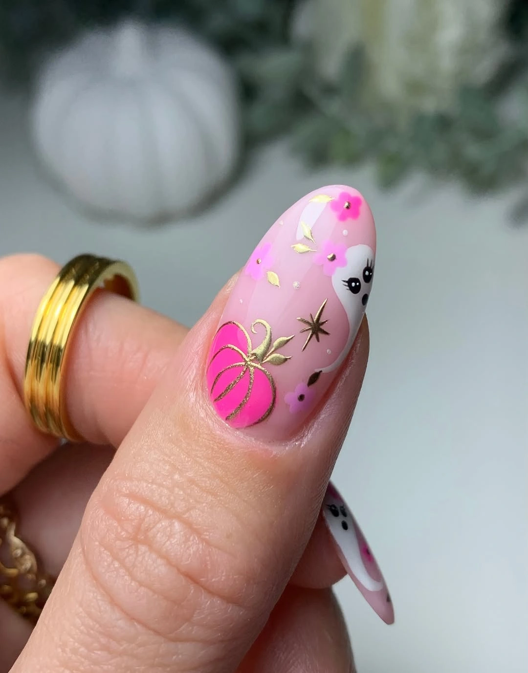Pink almond nails with lime green pumpkin and black graphic accents