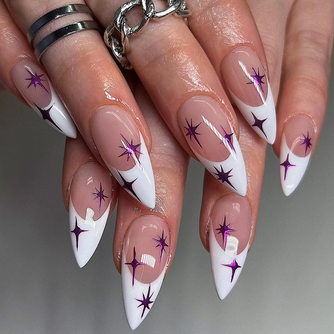 Long white stiletto nails with purple starburst nail art
