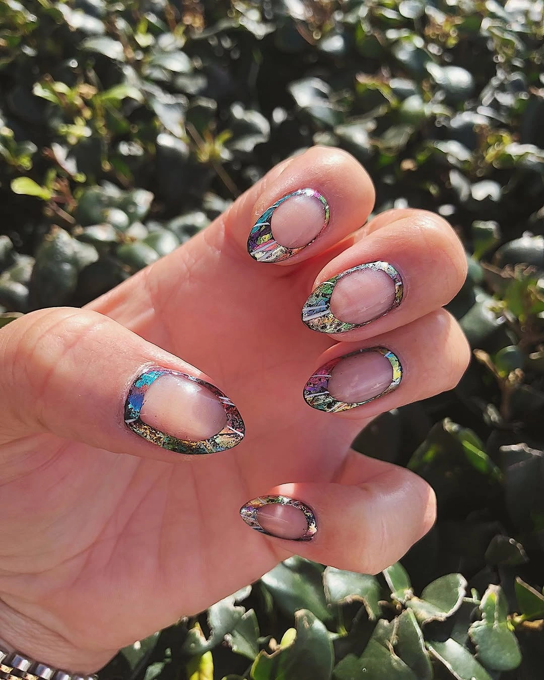 Short olive green nails with irregular metallic foil-like edges