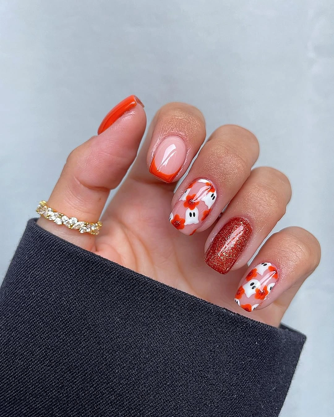 Short orange nude nails with white floral accents