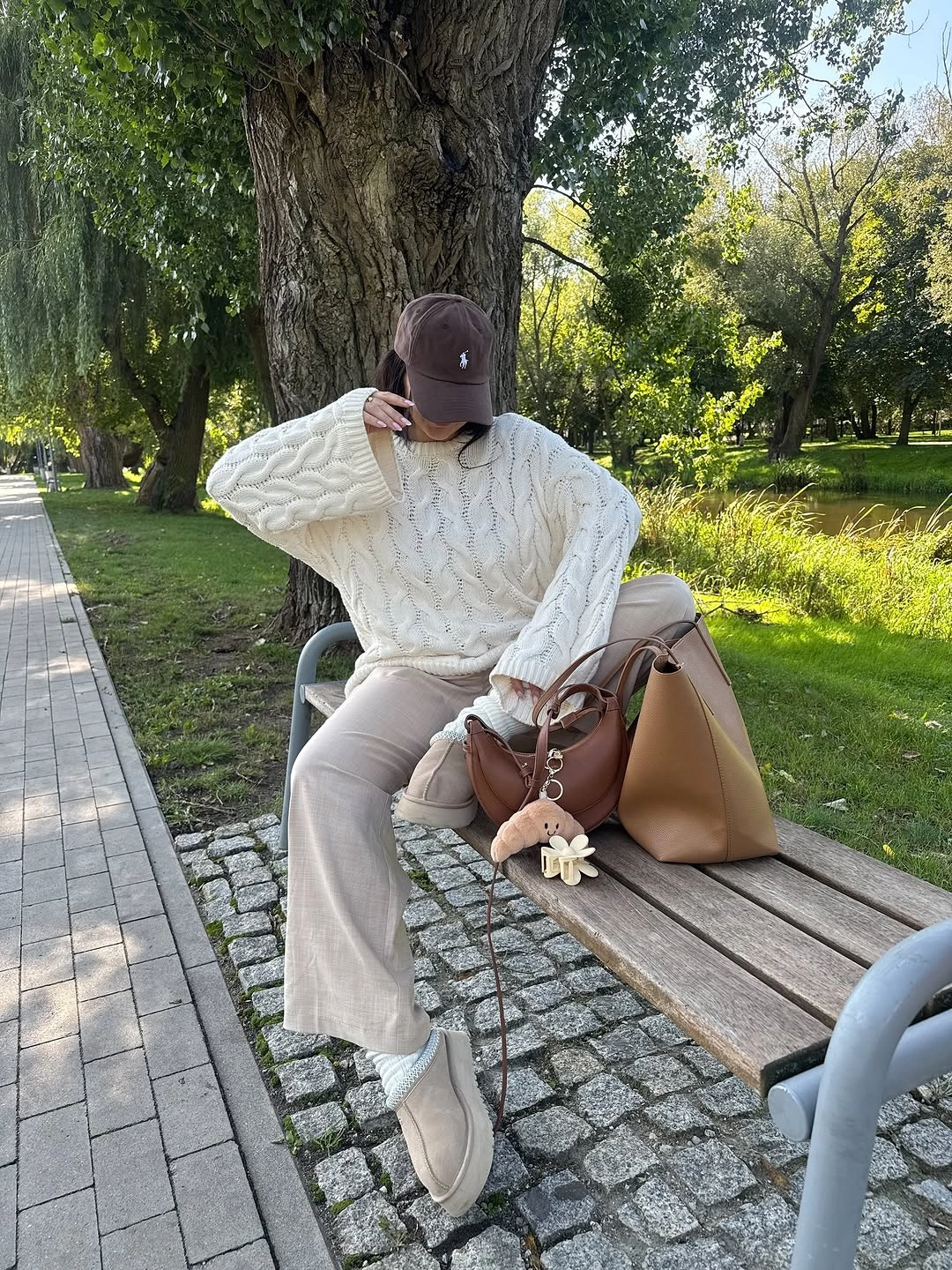 Cream cable sweater beige trousers brown cap and tan bag