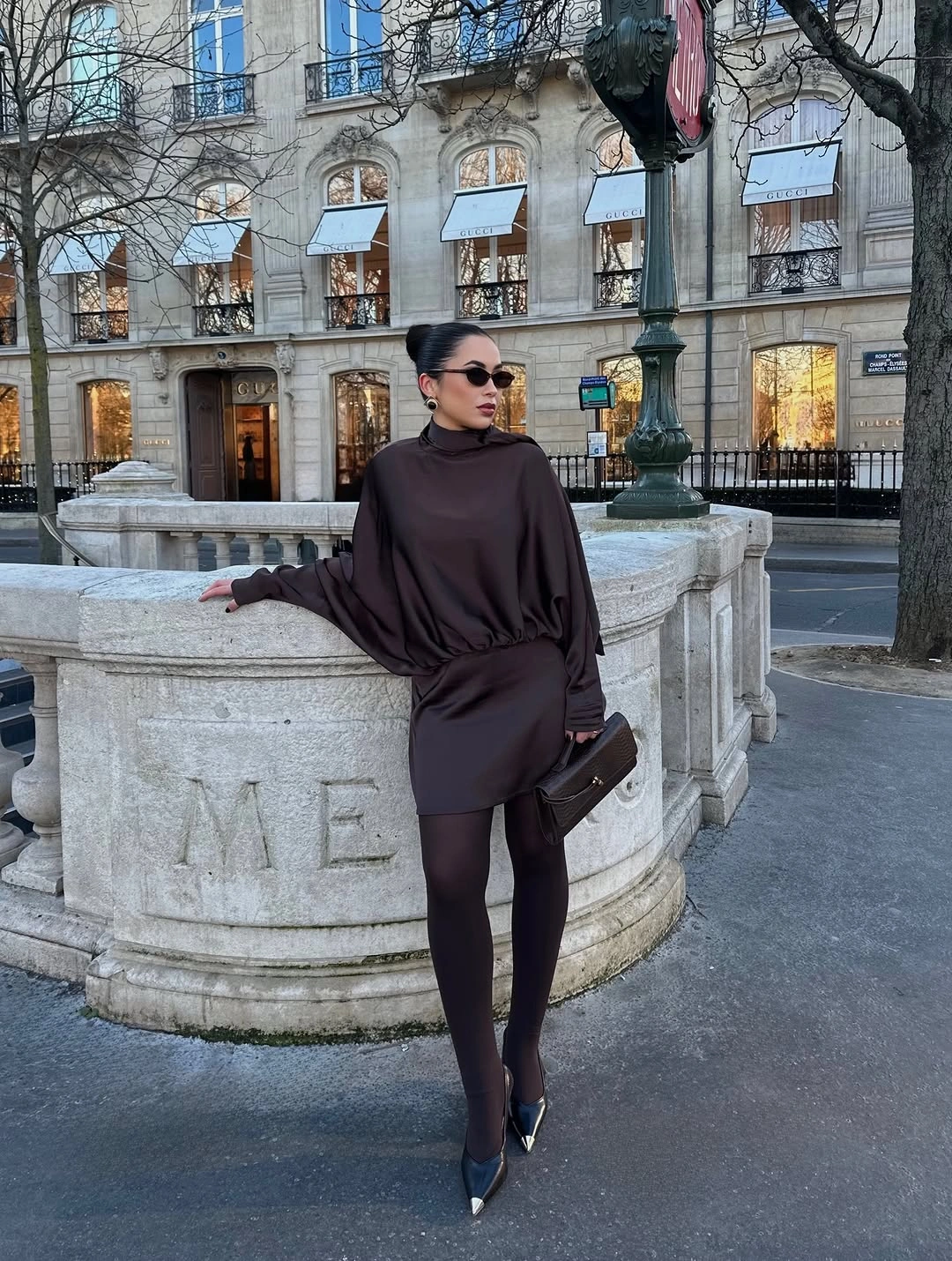 Draped dark brown mini dress black tights pointed shoes burgundy bag