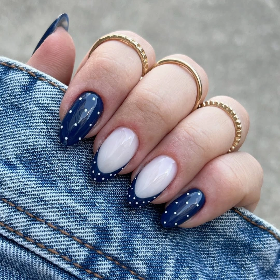 medium nails alternating navy and milky white with small contrasting dots