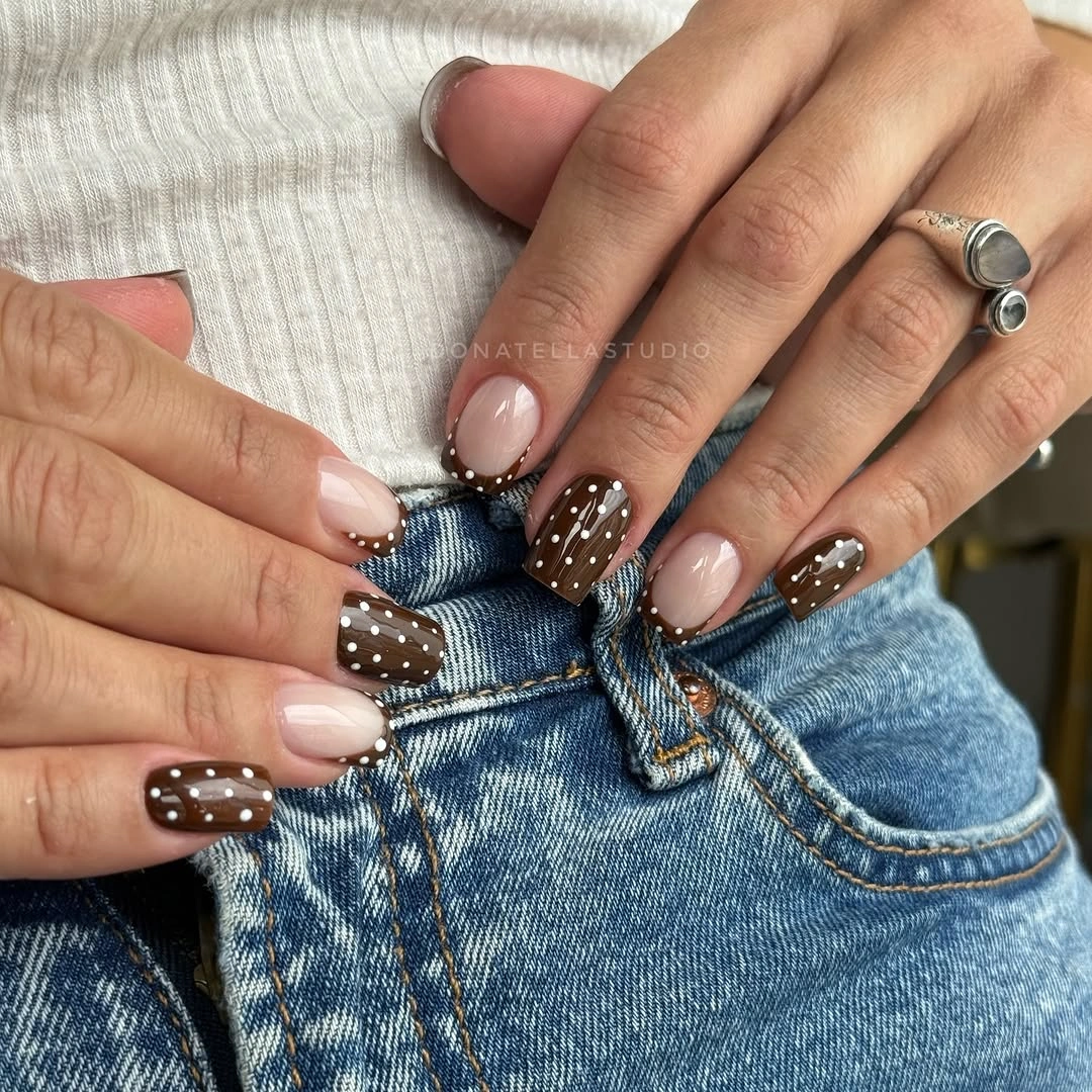 medium blush nails with dark brown polka accents and pale neutral companion nails