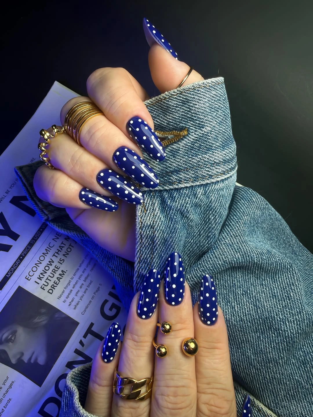 long cobalt blue almond nails with dense tiny white dots and gold accents