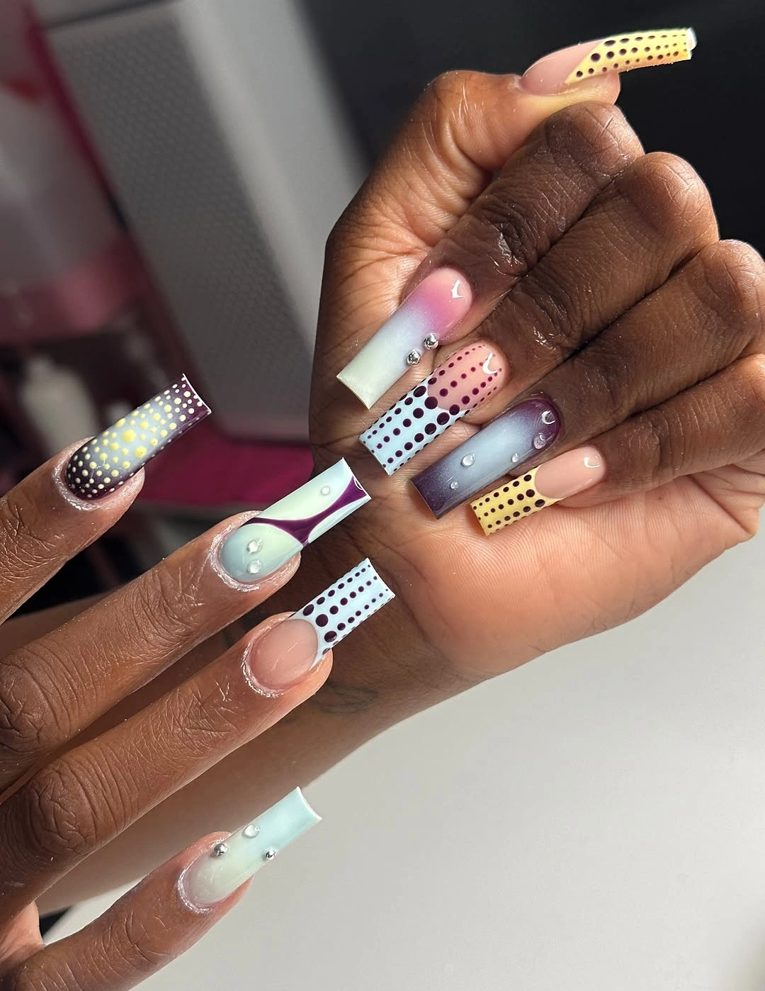 very long square nails with pastel color bands black dotted strips and gradient panels