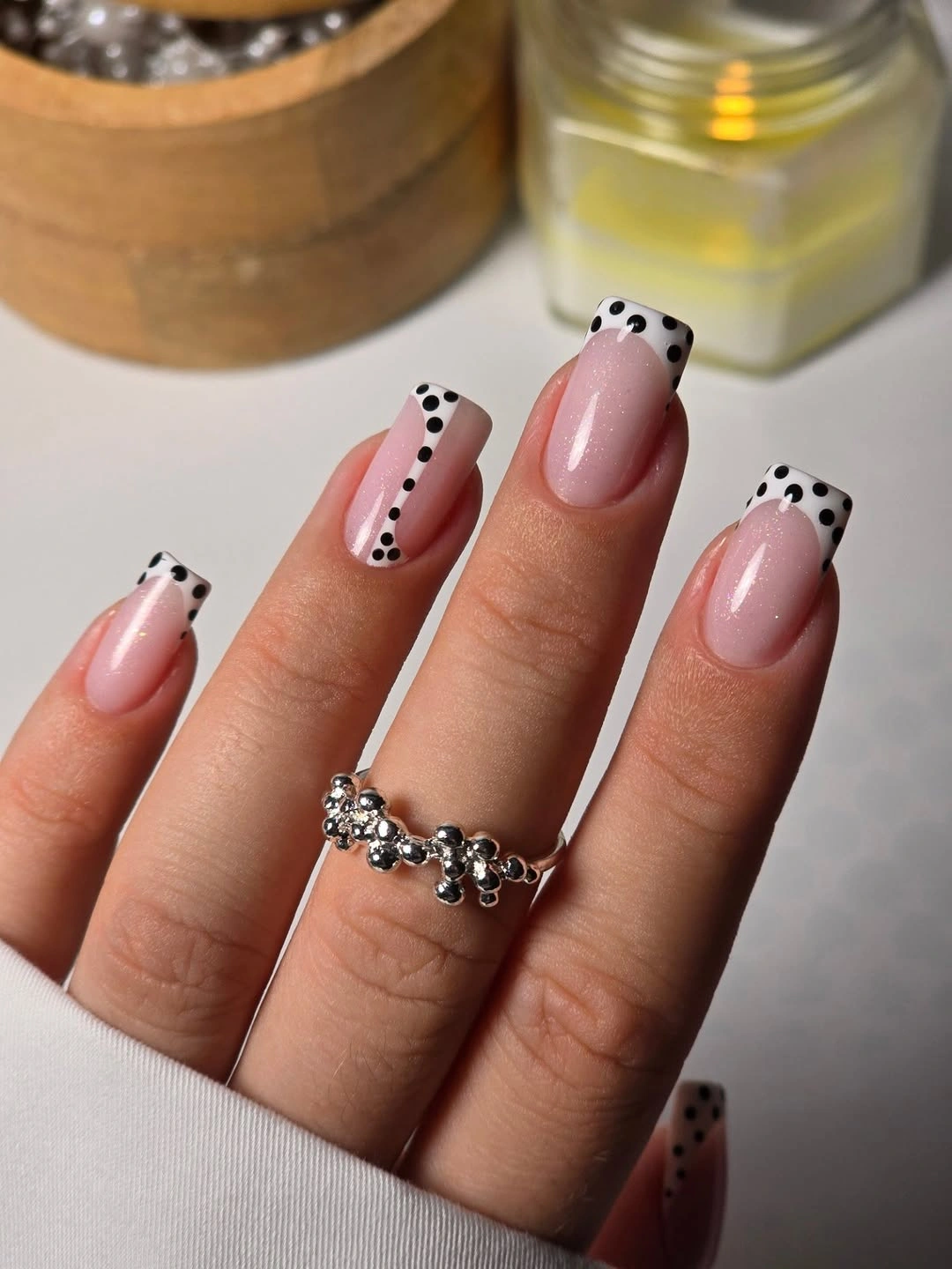 medium pale pink square nails with white French tips and black polka dots